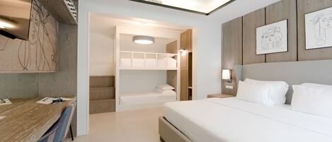 A modern hotel room with a large bed, a desk, and a built-in wardrobe.