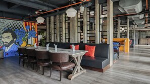 A modern interior with a dining area, a sofa, and a mural. - Sugar Marina Hotel - ART - Karon Beach (Karon)