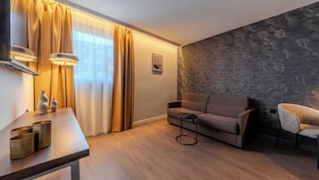Ein modernes Wohnzimmer mit einer Couch, einem kleinen Tisch und einem Sessel.