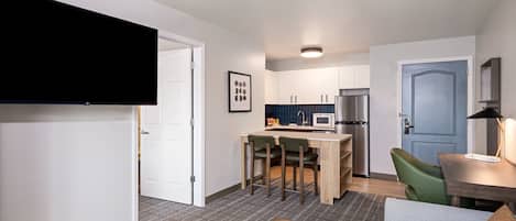 A modern apartment with a living room, kitchen, and dining area.