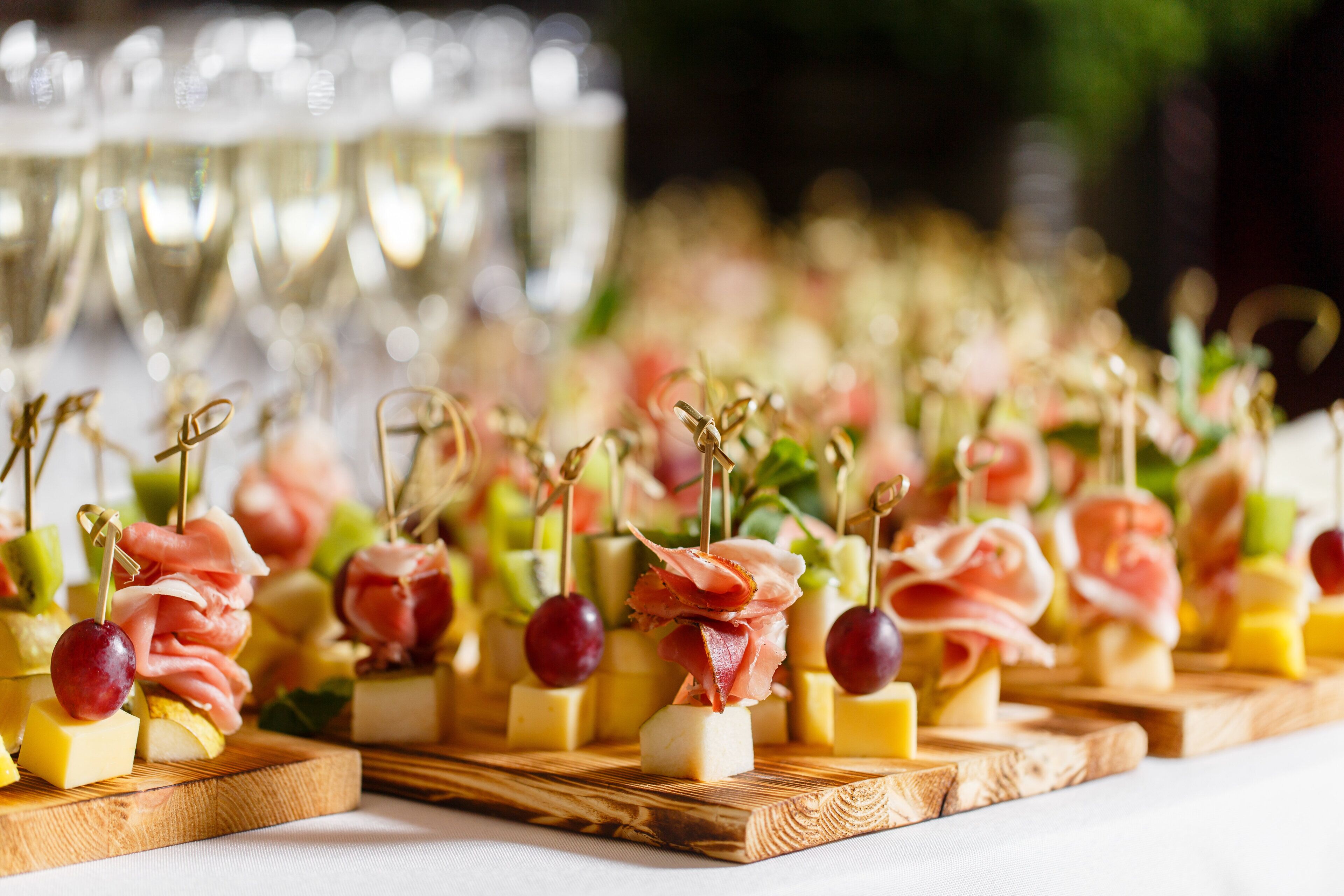 A table with food items, including cheese and grapes, arranged on wooden boards.