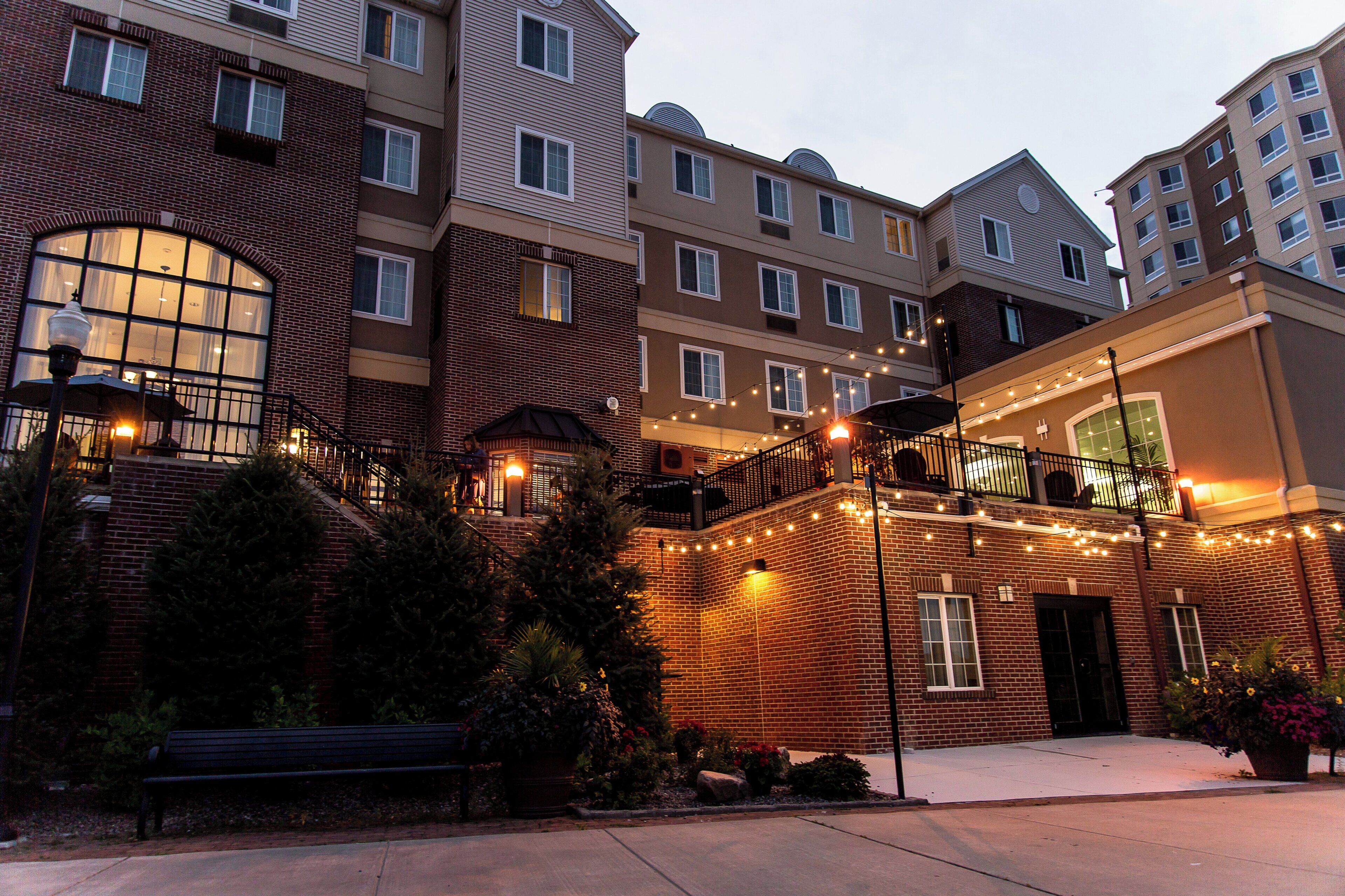 A multi-story building with a brick facade, large windows, and outdoor lighting.
