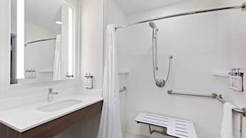 A modern bathroom with a white sink, a shower with a handheld showerhead, and a towel rack.