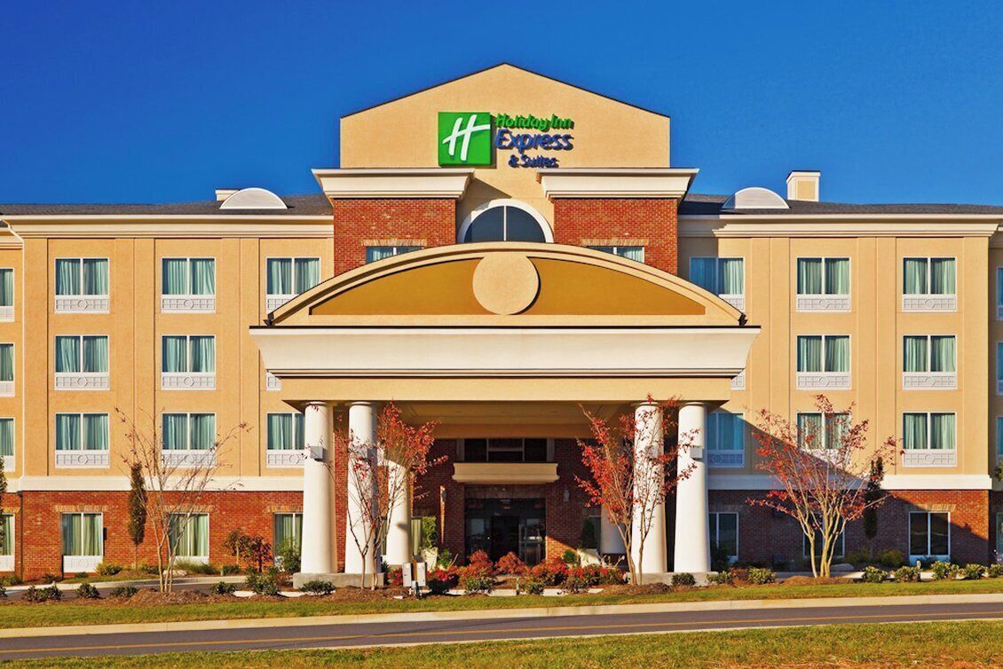 Un hôtel Holiday Inn Express doté d’une entrée centrale, de nombreuses fenêtres et d’une façade en briques.