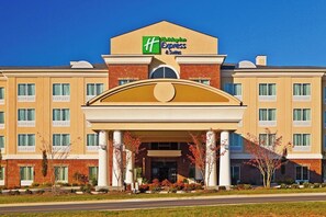 Um hotel Holiday Inn Express com entrada central, várias janelas e fachada de tijolos.