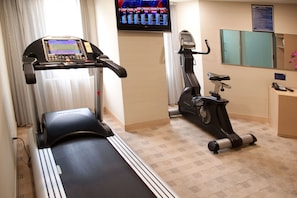 Stay active with a fully equipped fitness room featuring a stationary bike, treadmill, and TV for entertainment.