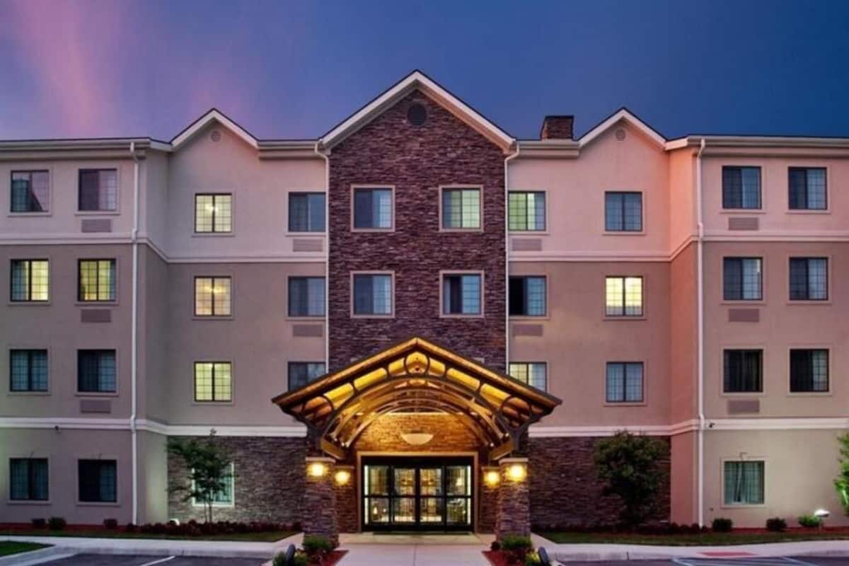 A multi-story hotel with a central entrance, multiple windows, and a stone facade.