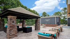 A patio area with stone pillars, outdoor seating, and a covered section. - Homewood Suites by Hilton Yorktown Newport News (Yorktown)