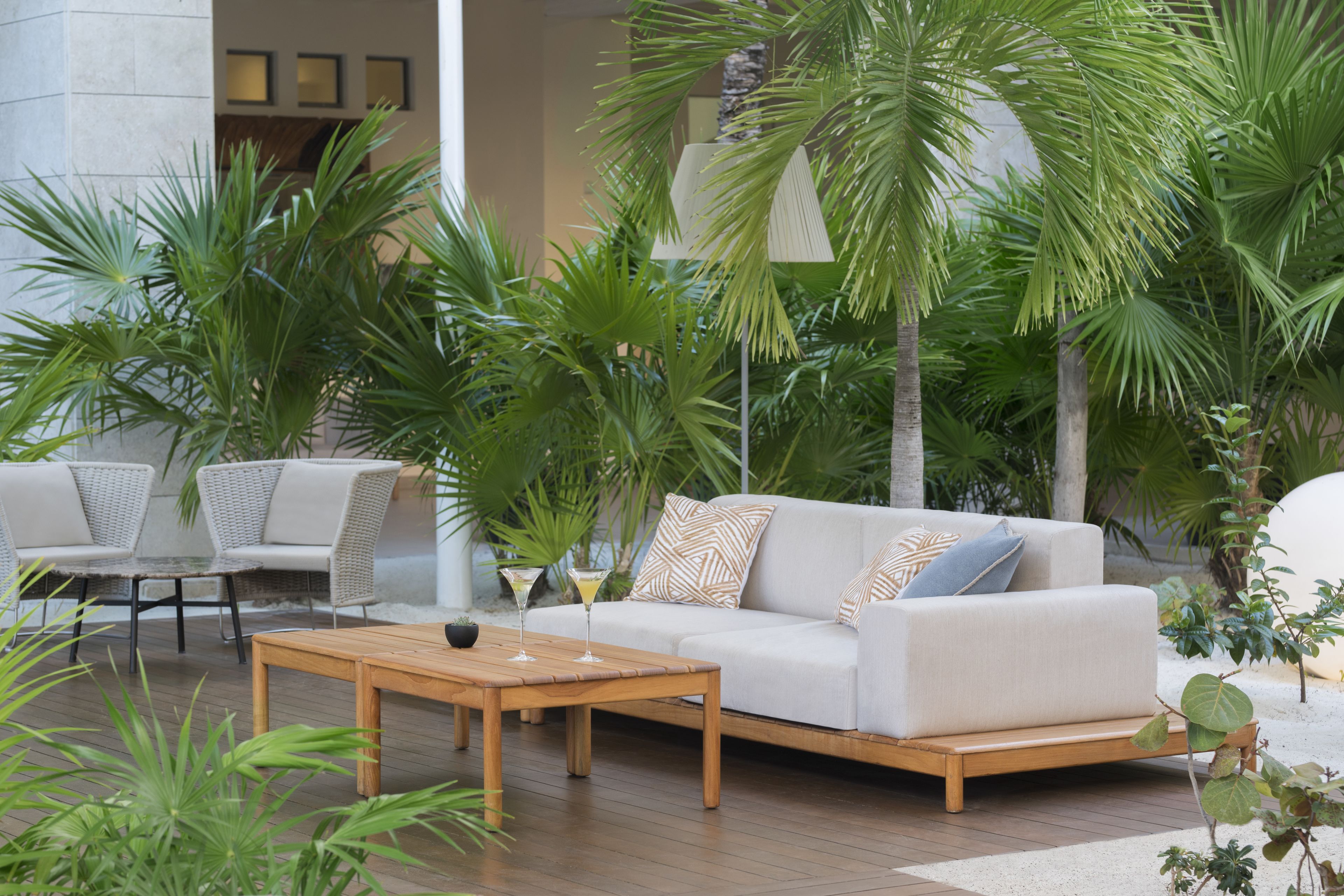 A modern outdoor seating area with a sofa, chairs, and a wooden table.