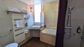 A modern bathroom with a bathtub, a toilet, a sink, and a shower.