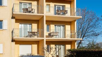 Un edificio de varios pisos con balcones, cada uno con mobiliario exterior.