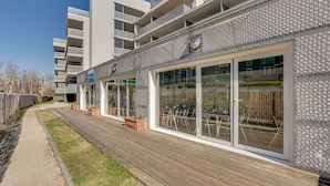 A modern building with a wooden deck, large glass windows, and a patterned facade. - ResidHotel Azuréa (Aix-les-Bains)