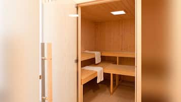 Un sauna en bois avec deux bancs et un plafond incliné.