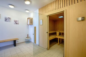 Un sauna en bois, avec des bancs à l’intérieur et un banc à l’extérieur.