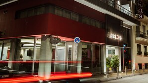Un hotel de varios pisos con fachada roja, balcones y ventanas iluminadas.