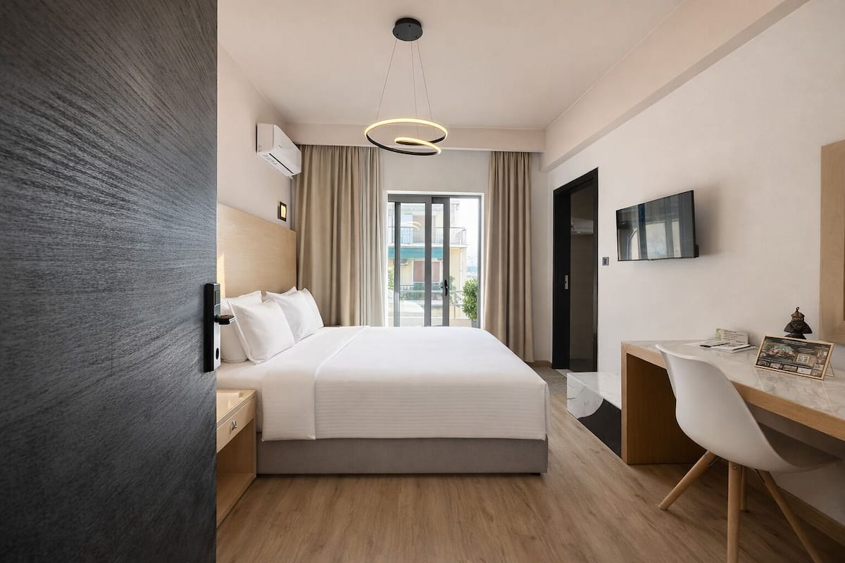 Une chambre d’hôtel moderne équipée d’un lit, d’un bureau et d’une télévision.