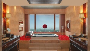 Un baño moderno con una bañera amplia, encimeras de mármol y vistas a través de amplias ventanas.