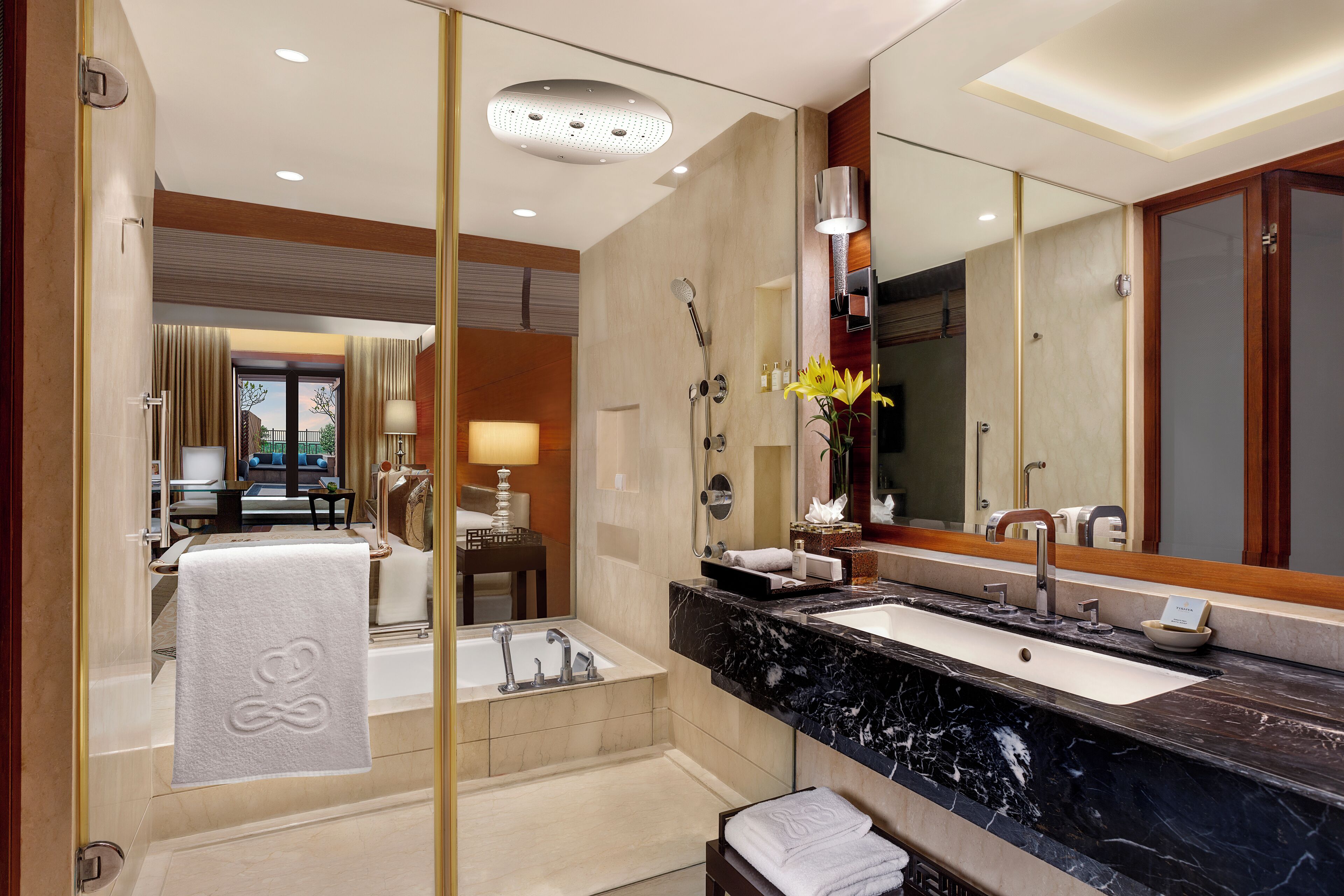 Un baño moderno con bañera, un espejo grande y un tocador con lavamanos.