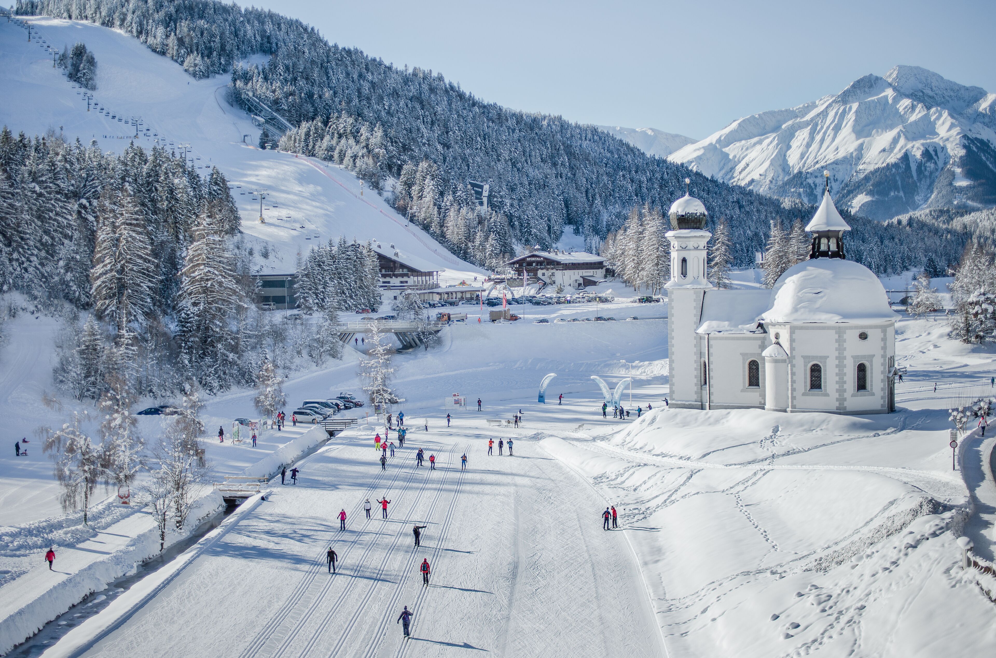 A snow-covered ski resort with a prominent church and a ski lift.