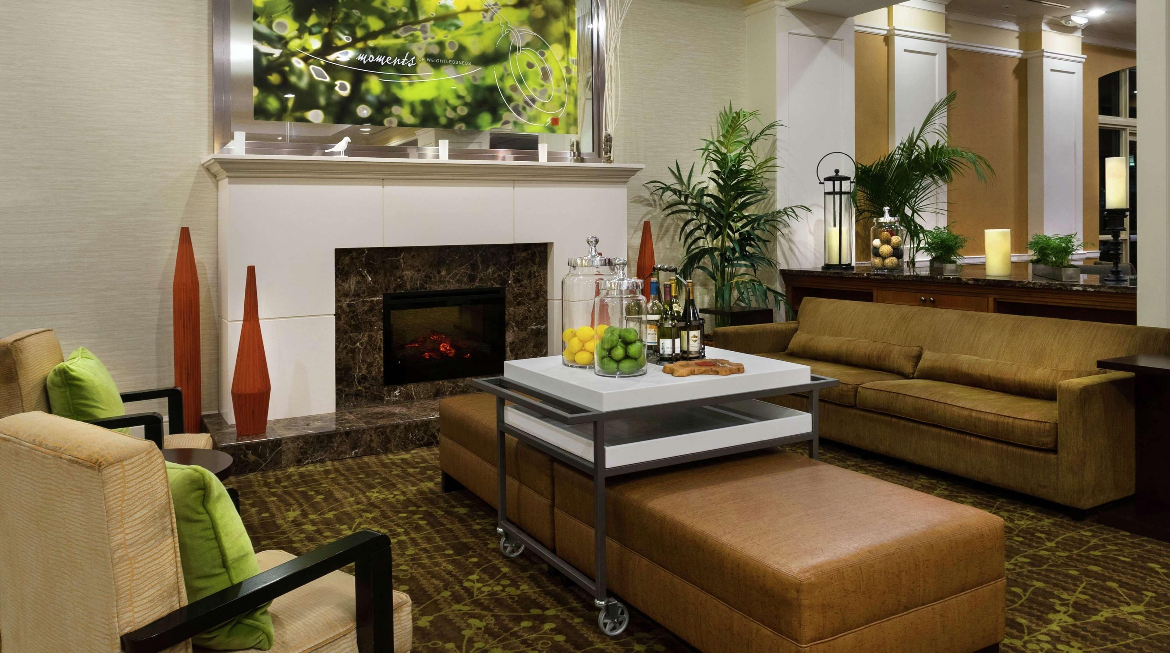 A modern living room with a fireplace, a sofa, a coffee table, and decorative vases.