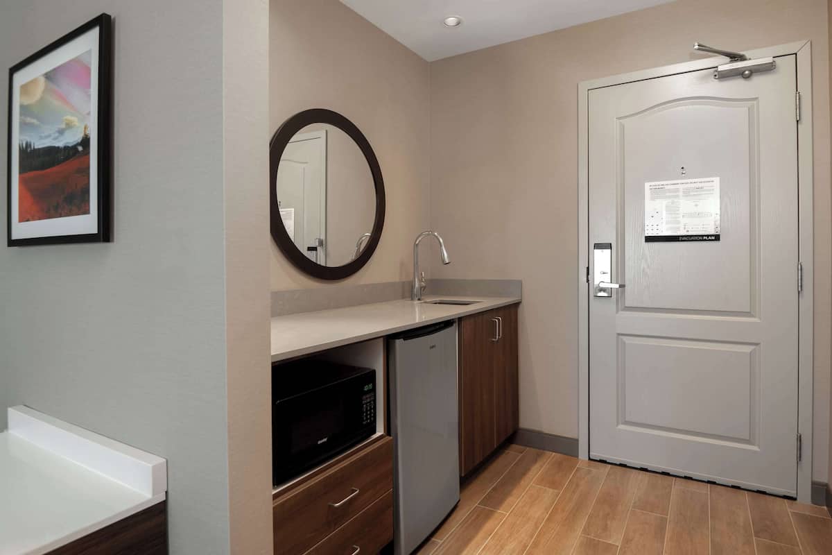 A compact kitchen with a microwave, dishwasher, and a sink.