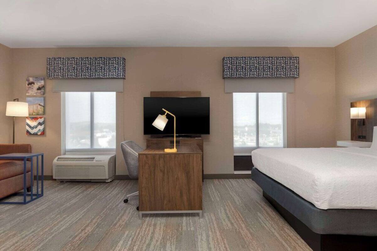 Escritorio, cortinas blackout y tabla de planchar con plancha