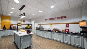 A breakfast area with a counter, seating, and a wall with a sign saying "HAPPY BREAKFAST STARTS HERE."