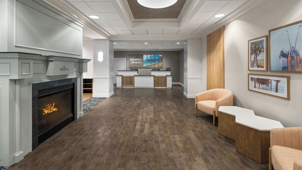 A lobby with a fireplace, reception desk, and seating area.