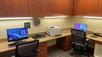 A professional office with two desks, each with a computer, office chairs, and a printer.
