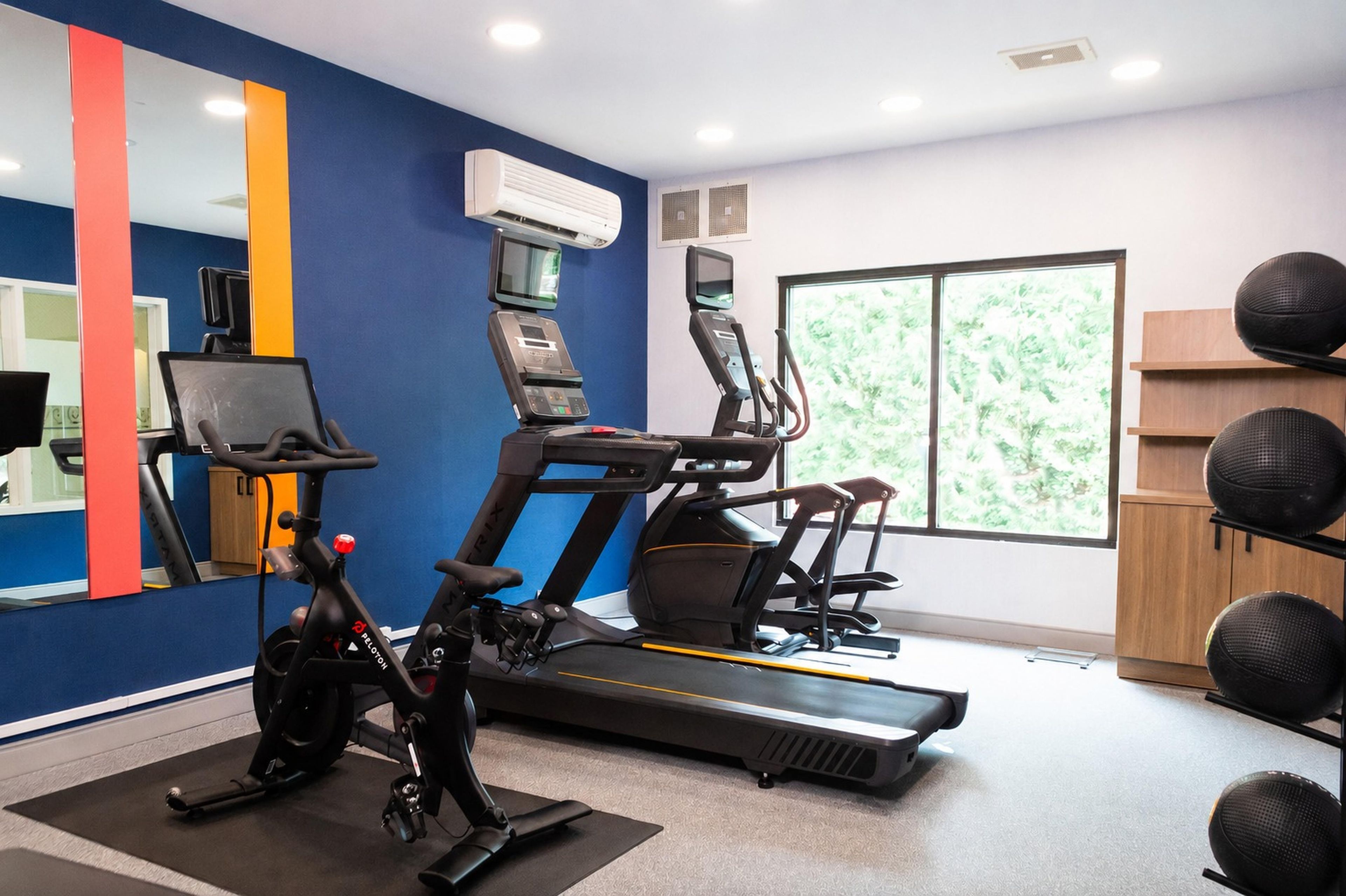 A home gym with a treadmill, stationary bike, and exercise equipment.