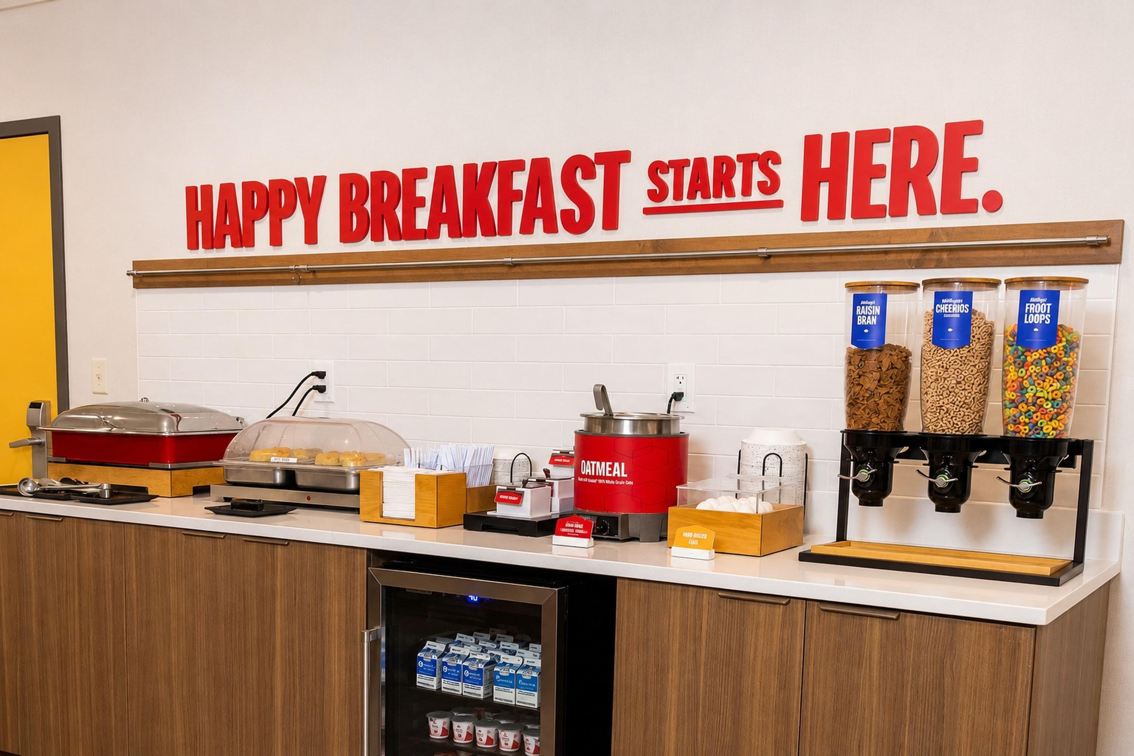 Ein Frühstücksbereich mit einem Schild, auf dem steht: 'HAPPY BREAKFAST STARTS HERE'.