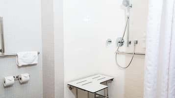 A modern bathroom with a shower, toilet, and towel rack.