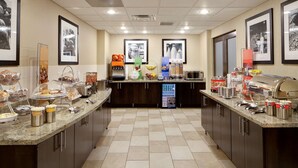 Een hotelkeuken met een buffetopstelling, inclusief diverse gerechten en een koffieapparaat.