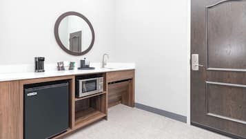 Un bagno moderno dotato di frigorifero integrato, forno a microonde e lavandino.