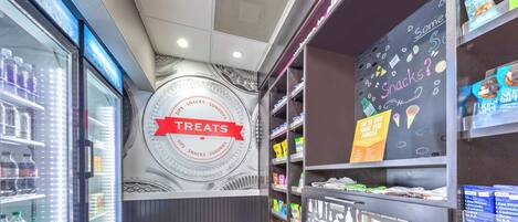 A snack and treat section with refrigerated display cases and shelves stocked with various snacks and treats.