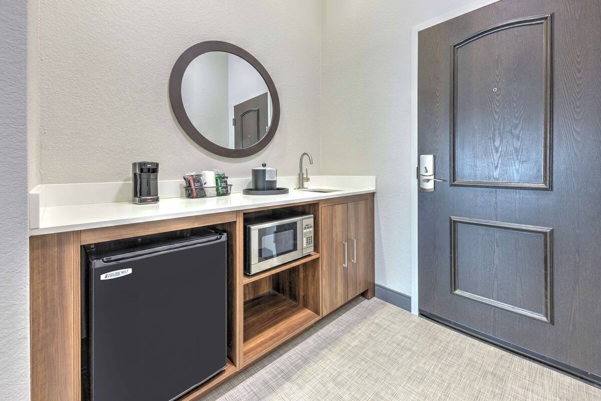 A compact bathroom with a built-in refrigerator, microwave, and sink.