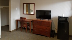 A hotel room with a wooden desk, a television, a microwave, and a mirror. - Beverly Lodge (South Lake Tahoe)
