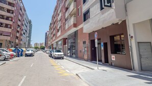 Un hotel llamado Zeus Hotel con una fachada moderna, varios pisos y un cielo despejado.