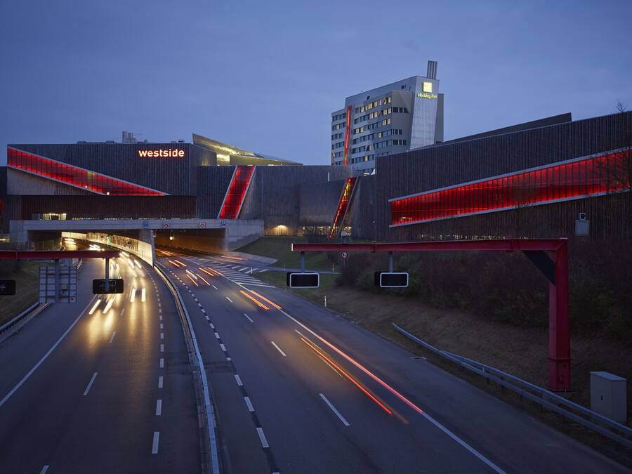 Una autopista que lleva a un edificio moderno con un letrero que dice 'westside'.