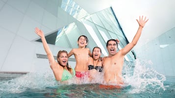 Un grupo de personas en una piscina con un fondo de arquitectura moderna.