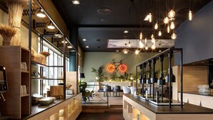 A modern interior with wooden shelves, a seating area, and hanging light fixtures. - Holiday Inn BERN-WESTSIDE by IHG (Bern)