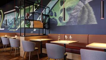 Un interior de restaurante moderno con mesas de madera, sillas tapizadas en gris y un gran mural de un oso en la pared.