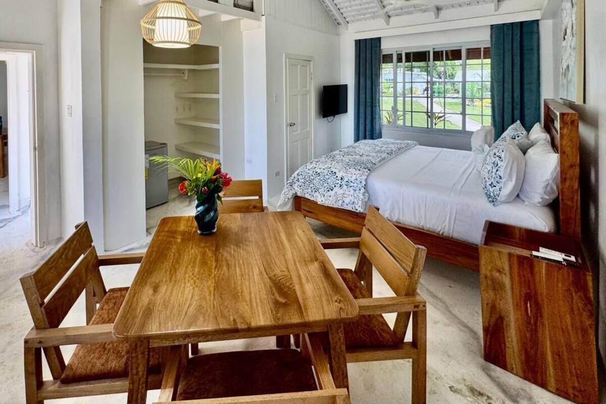 Une chambre à coucher avec un lit, une table de chevet et une vue sur l’extérieur.