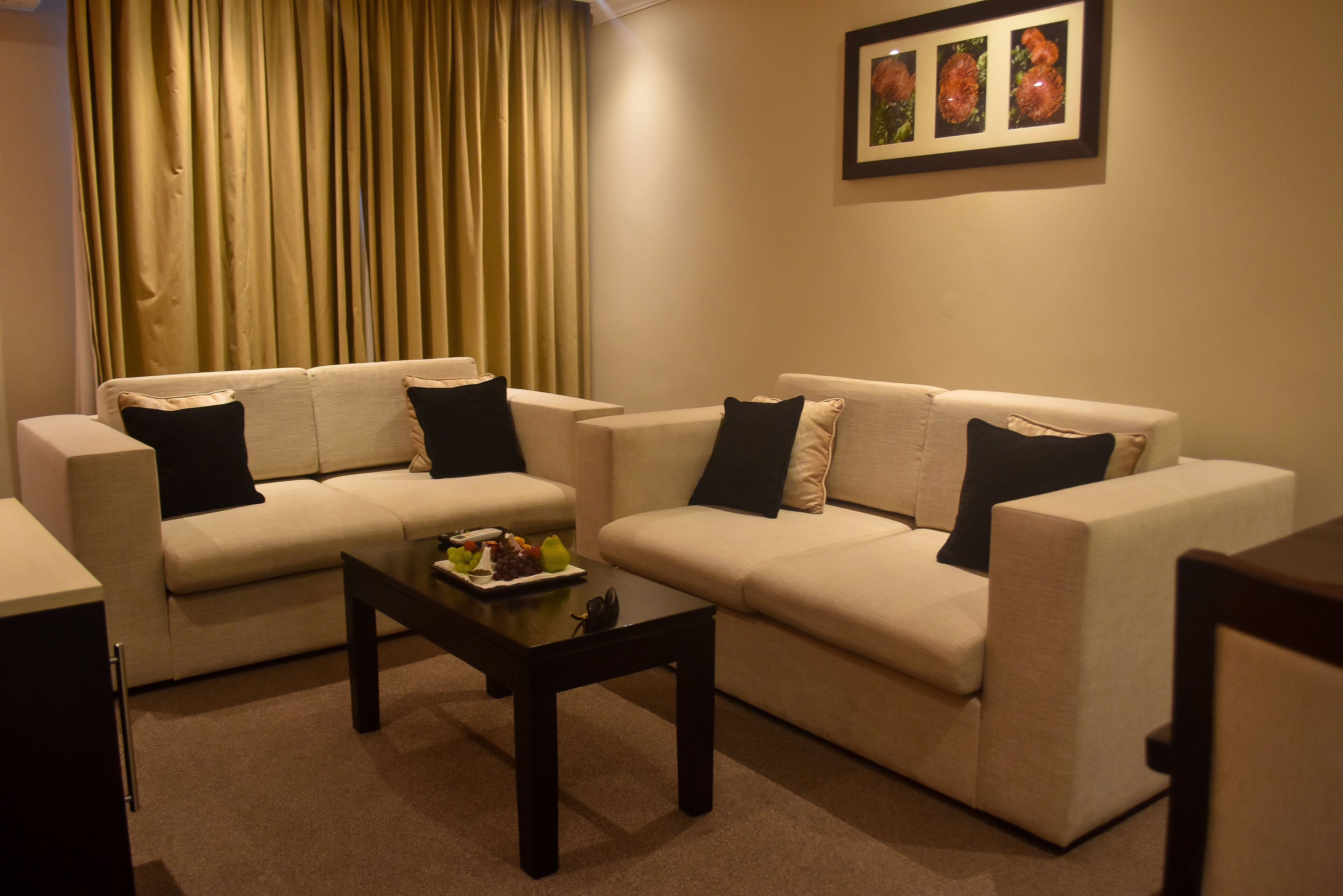A living room with two sofas, a coffee table, and a framed picture on the wall.