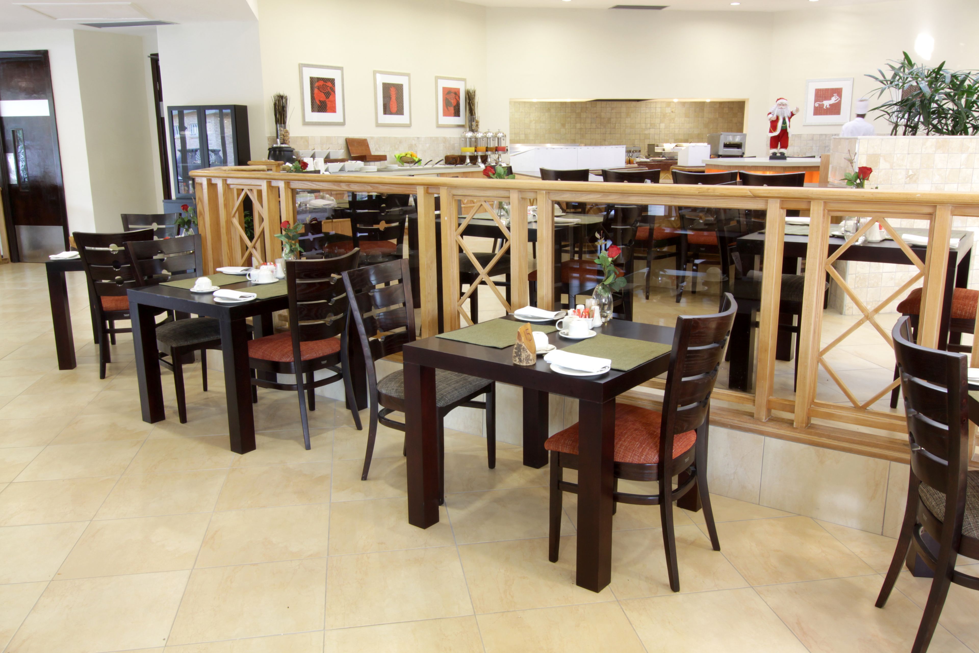 Un restaurant doté de nombreuses tables et chaises, d’un comptoir et d’une grande fenêtre.