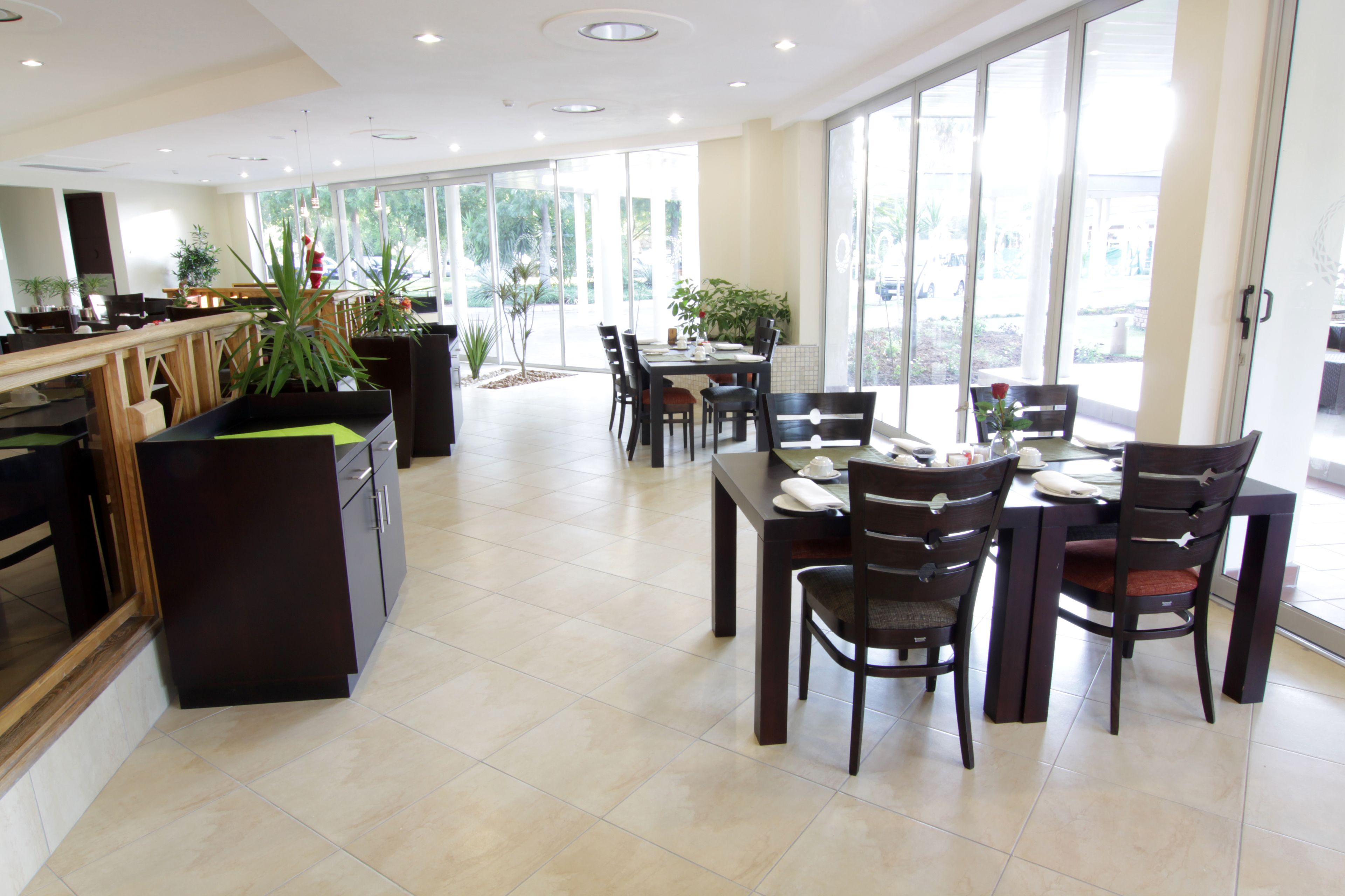 Un comedor espacioso con una gran mesa y sillas, rodeado de amplias ventanas con vistas al exterior.