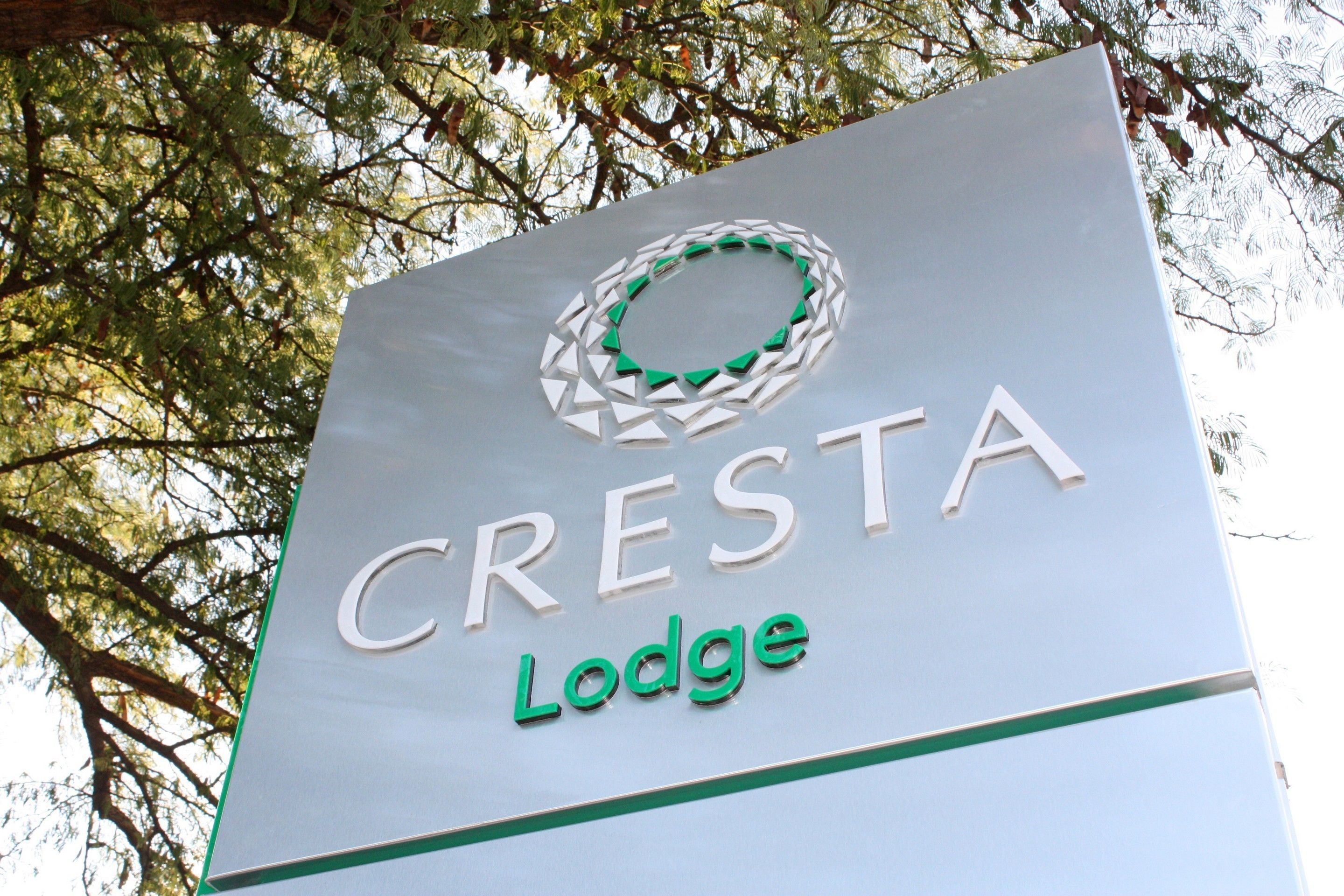 A sign for Cresta Lodge with a circular logo and the name 'CRESTA Lodge' in capital letters.