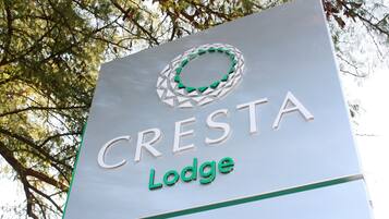 A sign for Cresta Lodge with a circular logo and the name 'CRESTA Lodge' in capital letters.