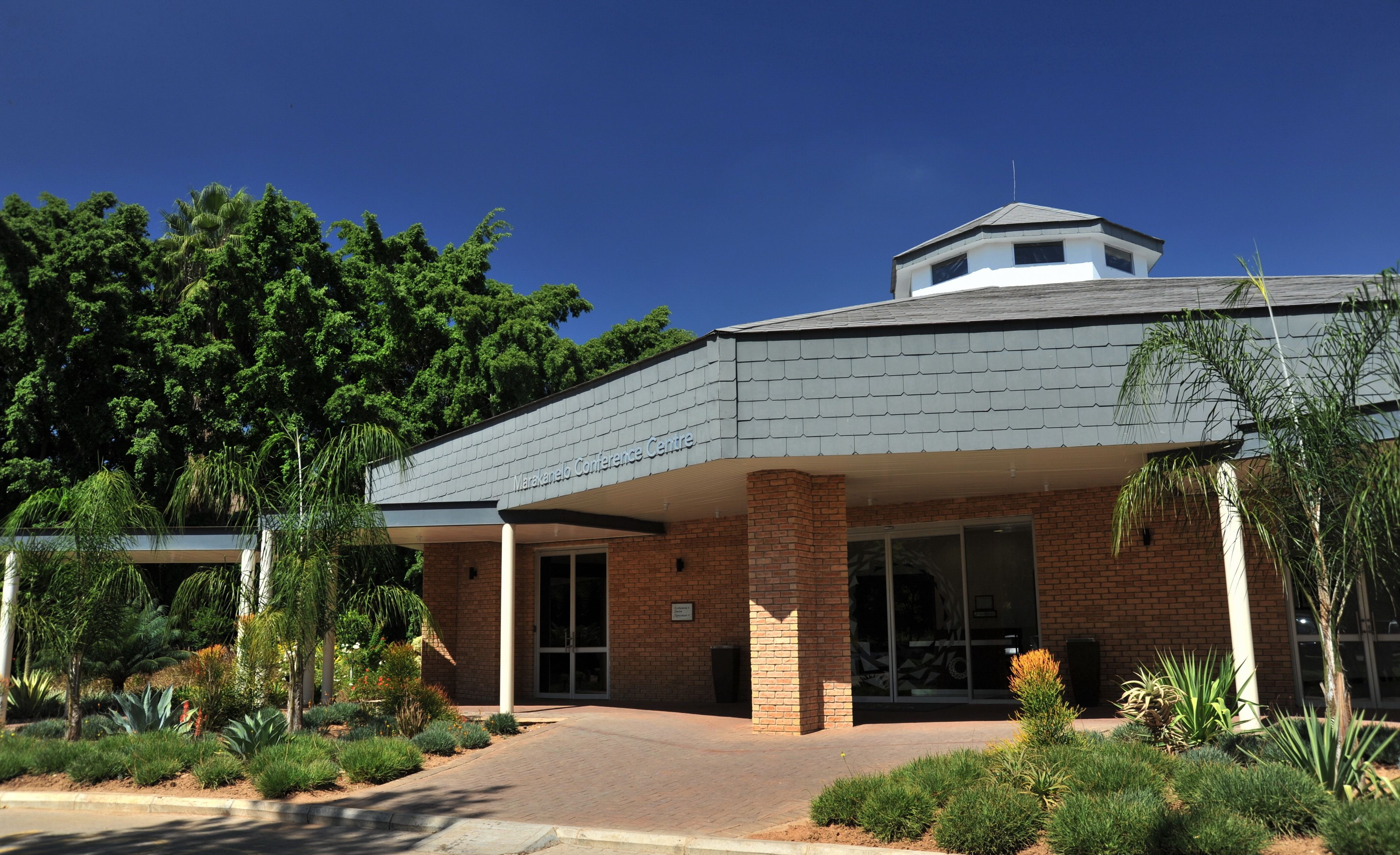 A building with a brick facade, a covered entrance, and a small tower-like structure on the roof.