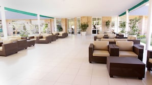 A spacious indoor lounge area with multiple seating arrangements and large windows providing natural light. - Cresta Lodge Gaborone (Gaborone)